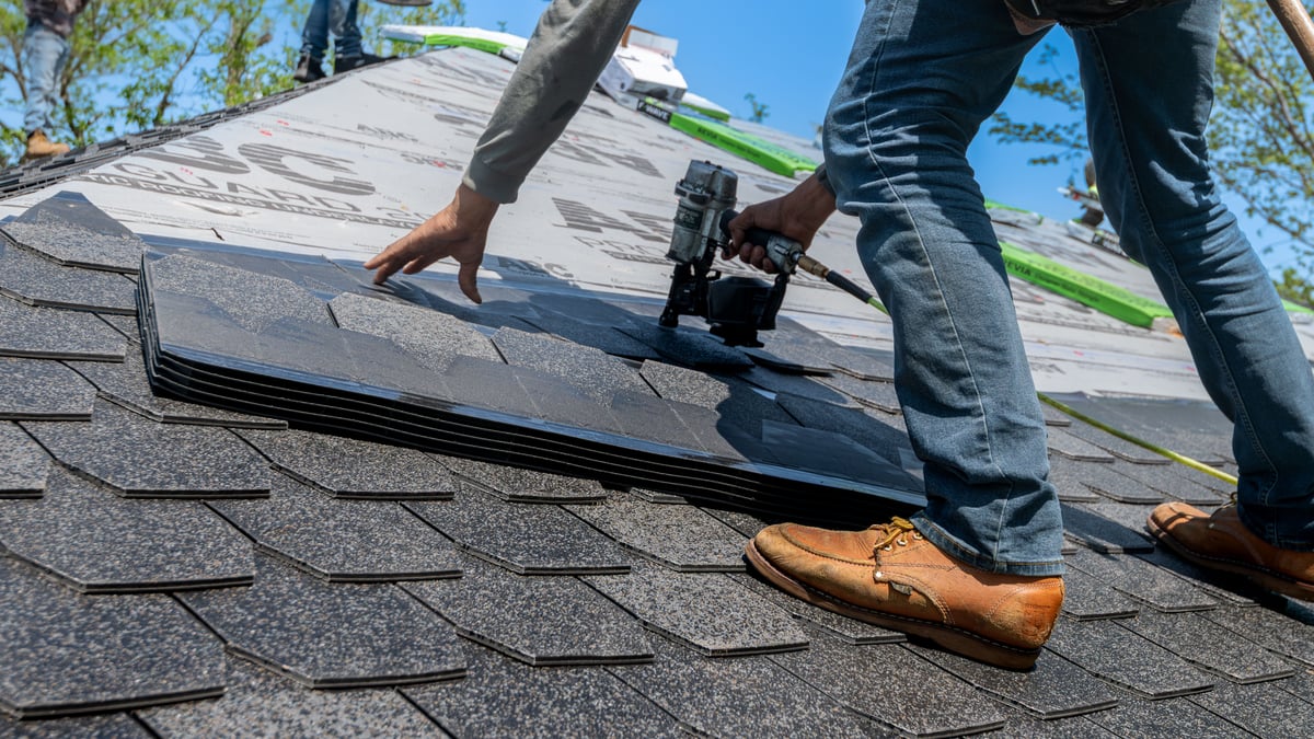 Contractor measuring a roof before replacement