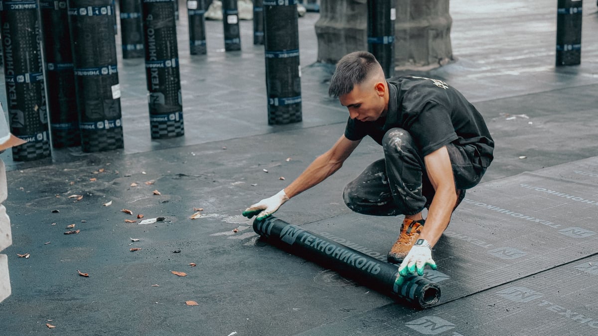 Roofer checking seams on a flat roof