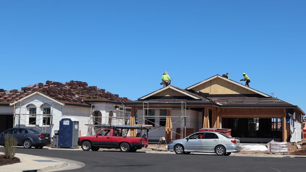 Crew removing old shingles during roof replacement