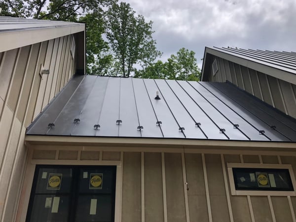 New metal roof on a house with beige siding