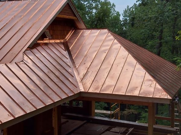 Copper roof sections on a wooded building