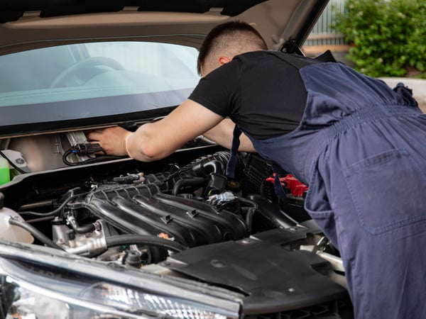 A mechanic performing maintenance work on a car's